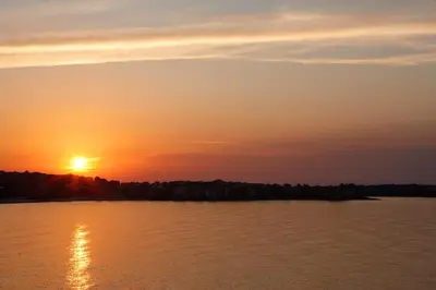 a sunset over a large body of water at Apartments 