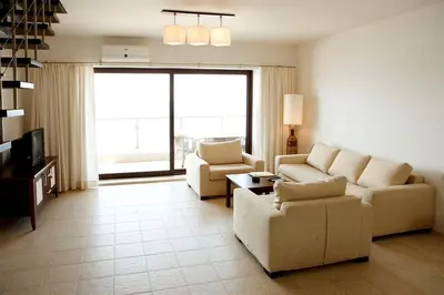 a living room with a couch and chairs and a tv at Apartments 