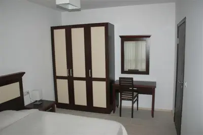 a bedroom with a bed and a desk and a mirror at Apartments 