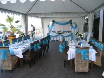 a tent with tables and chairs with blue bows at Apartments 