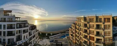 two tall buildings next to a body of water at By The Cliffs apartments in Byala