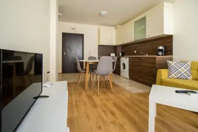 a kitchen and living room with a table and chairs at By The Cliffs apartments in Byala