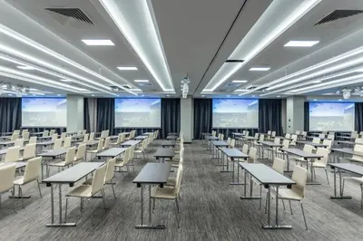 a classroom with desks and chairs in a room with large windows at Hotel Bulgaria in Burgas City