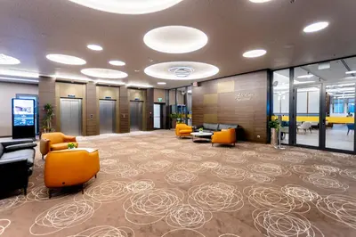 a large lobby with orange chairs and tables in a building at Hotel Bulgaria in Burgas City