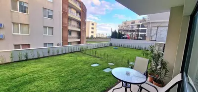 a balcony with a table and a green yard at GG Garden Deluxe in Chernomorets