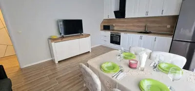 a kitchen with a table with green plates on it at GG Garden Deluxe in Chernomorets