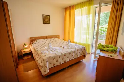 a bedroom with a bed and a large window at MNG Holiday Yassen Apartments in Sunny Beach