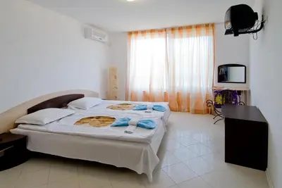 a bedroom with a bed and a television in it at MNG Holiday Yassen Apartments in Sunny Beach