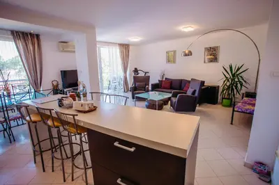 a kitchen and living room with a couch and a table at MNG Holiday Yassen Apartments in Sunny Beach