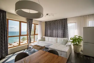 a living room with a white couch and a table at Penthouse at White Cliffs in Byala