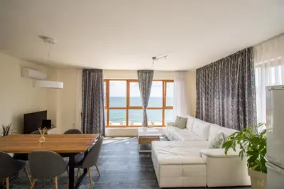 a living room with a white couch and a table at Penthouse at White Cliffs in Byala