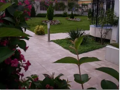 a garden with a walkway with plants and flowers at Albatros 2 Family Hotel in Kiten