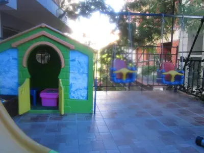 a play house with chairs and a slide at Albatros 2 Family Hotel in Kiten