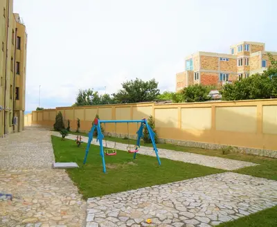 a swing set in a yard next to a building at Apartments Paskalina in Byala