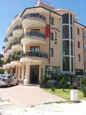 a building with a car parked in front of it at Family Hotel Golden Lion in Primorsko