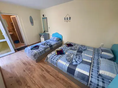 two beds in a room with wooden floors at Villa SUN in Kiten