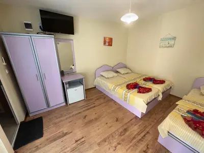 a small bedroom with two beds and a mirror at Villa SUN in Kiten