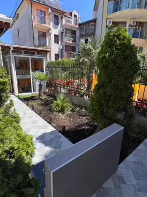 a garden in front of a building with plants at Villa SUN in Kiten