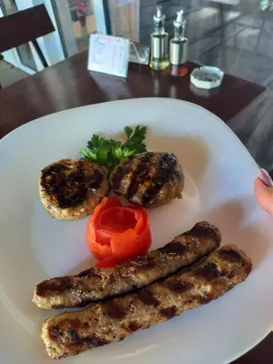 a plate of food with sausage and peppers on a table at хотел Централ in Sozopol