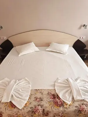 a white bed with two pillows on top of it at Palma in Burgas City