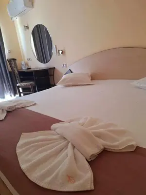 a bed with two towels laying on it at Palma in Burgas City