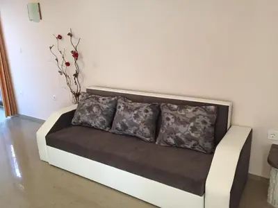 a couch with two pillows on it in a room at Guest House Afrodita in Chernomorets