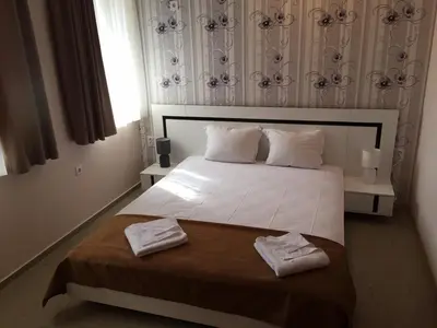 a bedroom with a white bed with two towels on it at Guest House Afrodita in Chernomorets