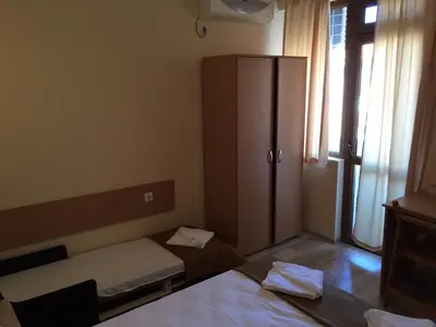 a small bedroom with a bed and a cabinet at Guest House Afrodita in Chernomorets