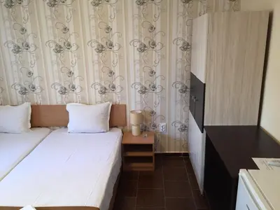 a hotel room with a bed and a small table at Guest House Afrodita in Chernomorets