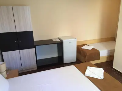 a small room with two beds and a small cabinet at Guest House Afrodita in Chernomorets