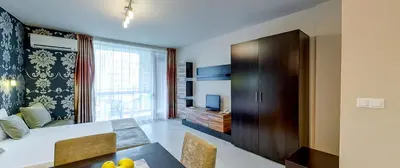 a living room with a table and a dining room at Briz Beach Apartments in Sunny Beach