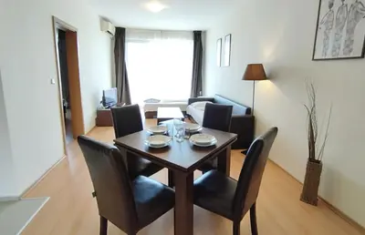 a dining room table and chairs in a living room at New Line Village Apartments in Sunny Beach