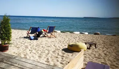 two chairs on a beach next to the water at New Line Village Apartments in Sunny Beach