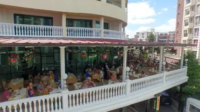 a group of people sitting at tables in a restaurant at Planeta Hotel & Aquapark FREE Beach Access - ULTRA All Inclusive in Sunny Beach