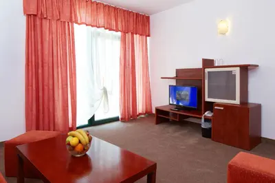 a living room with a bowl of fruit on a table at Mena Palace Hotel - All Inclusive in Sunny Beach