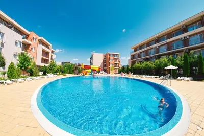 a person swimming in a large swimming pool at Holiday and Orchid Fort Noks Apartments in Sunny Beach