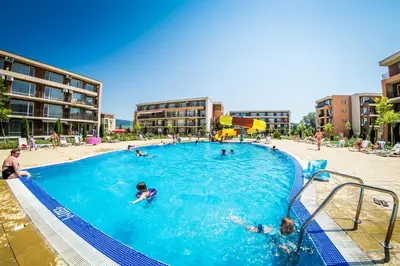 a group of people swimming in a swimming pool at Holiday and Orchid Fort Noks Apartments in Sunny Beach