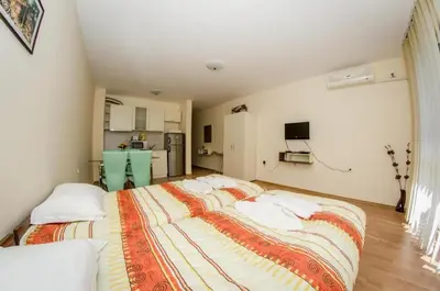 a bedroom with a large bed with white pillows at Holiday and Orchid Fort Noks Apartments in Sunny Beach