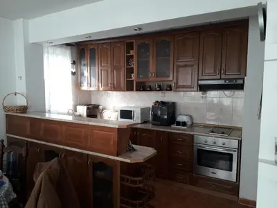 a kitchen with wooden cabinets and a stove top oven at Family style, main street, 20 minutes from the sea in Burgas City