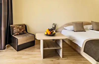 a bedroom with a bed and a table with a bowl of fruit at Alex Village in Shkorpilovtsi