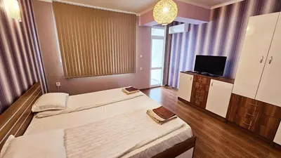 a hotel room with two beds and a television at Green House Apartment in Burgas City