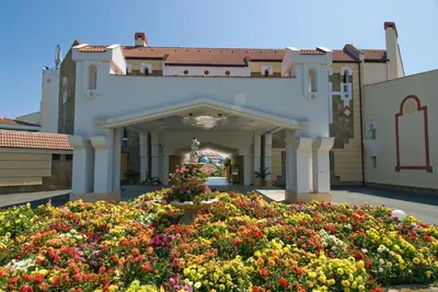 a building with a flower garden in front of it at Duni Pelican Hotel - All Inclusive in Sozopol