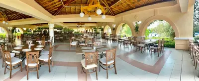 a restaurant with tables and chairs in a building at Duni Belleville - All Inclusive in Sozopol
