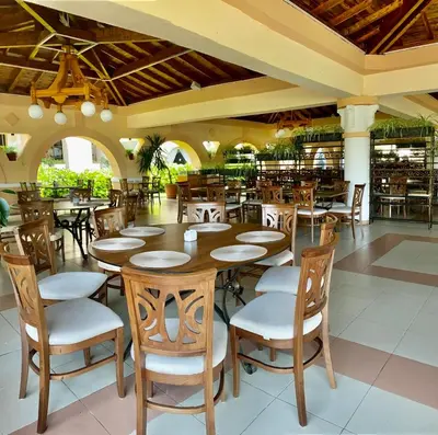 a dining room with wooden tables and chairs at Duni Belleville - All Inclusive in Sozopol