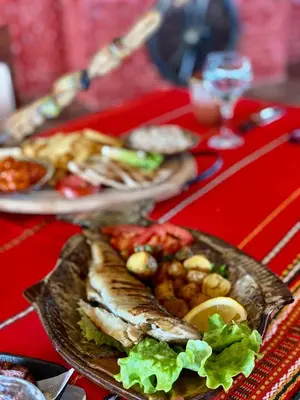 a plate of food with fish and vegetables on a table at Duni Belleville - All Inclusive in Sozopol