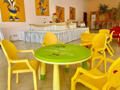 a green table and yellow chairs in a room at Duni Belleville - All Inclusive in Sozopol