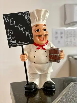 a figurine of a chef holding a welcome sign at Duni Marina Royal Palace Hotel - Ultra All Inclusive in Sozopol