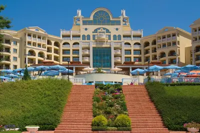 a large building with blue umbrellas in front of it at Duni Marina Royal Palace Hotel - Ultra All Inclusive in Sozopol