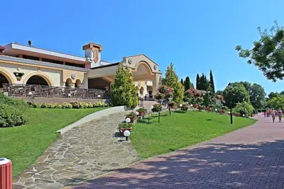 a building with a walkway in front of a park at Duni Holiday Village - All Inclusive in Sozopol