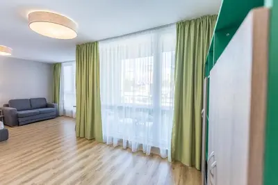 a living room with a couch and a large window at BSA Boulevard Boutique in Sunny Beach